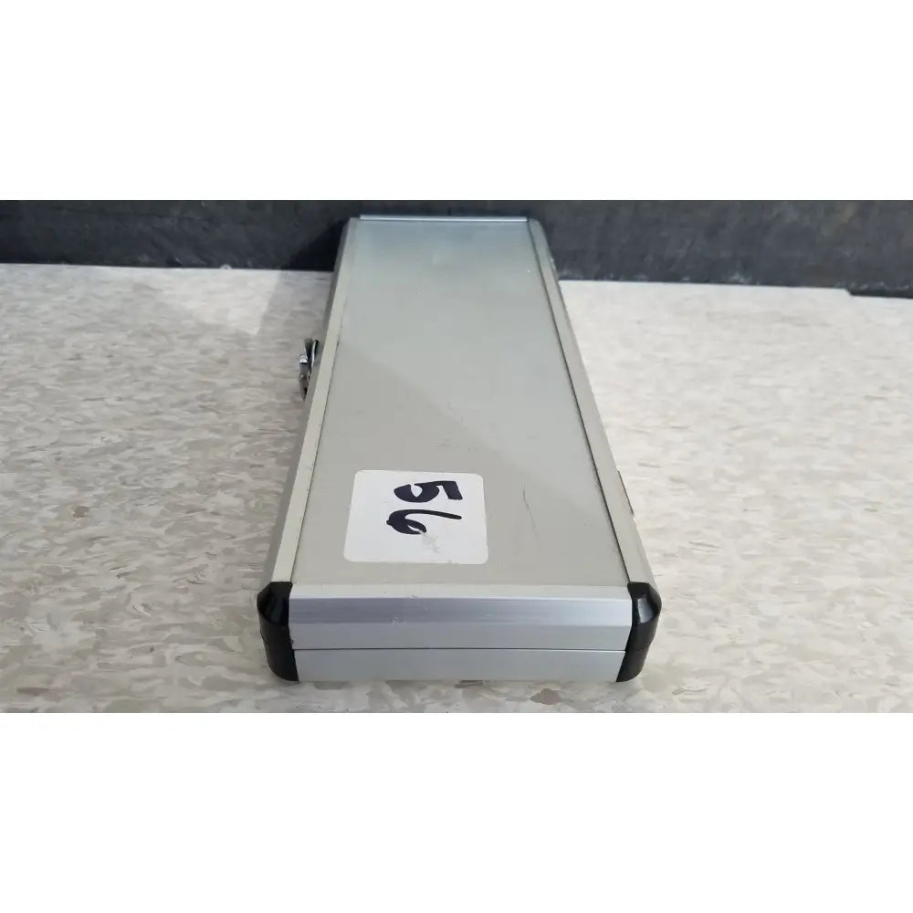 Silver hard protective case with black plastic corners and white number 56 sticker on the back side