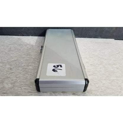 Silver hard protective case with black plastic corners and white number 56 sticker on the back side