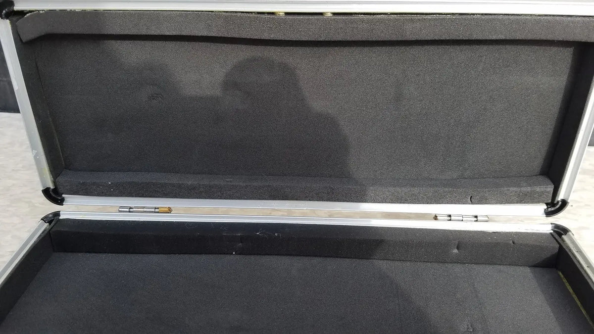Silver hard protective flight case with aluminum exterior and black foam interior for secure equipment storage
