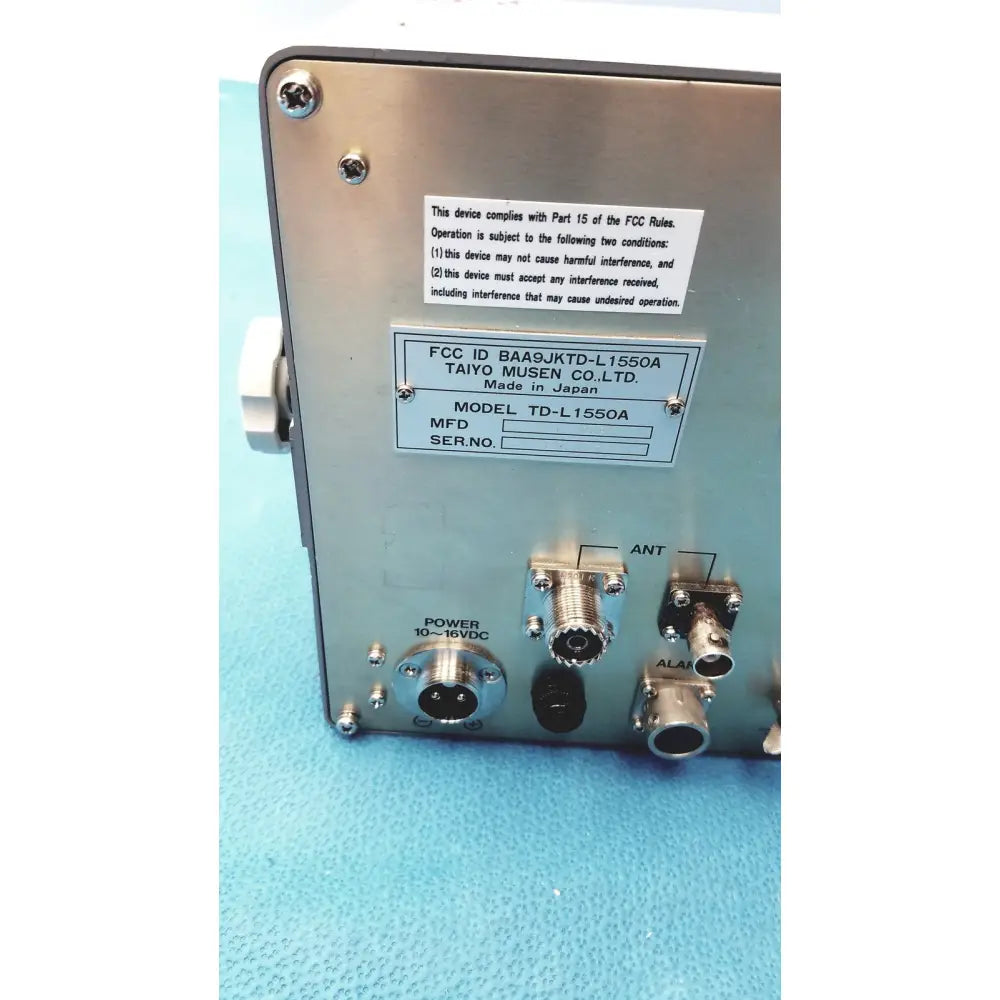 Silver metallic synthesized vhf automatic digital direction finder by simrad taiyo with labeled ports and fcc compliance sticker