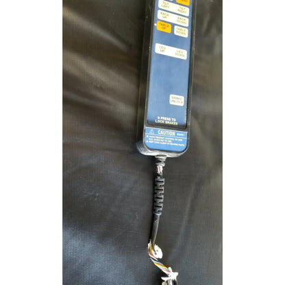 Blue skytron 1700 surgical table hand control panel with yellow white buttons black housing and coiled cable exposed wires