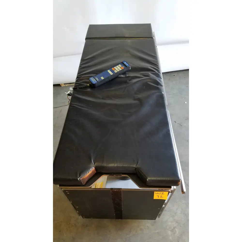 Black padded skytron 1700 surgical table with blue hand control for efficient reuse medical procedures