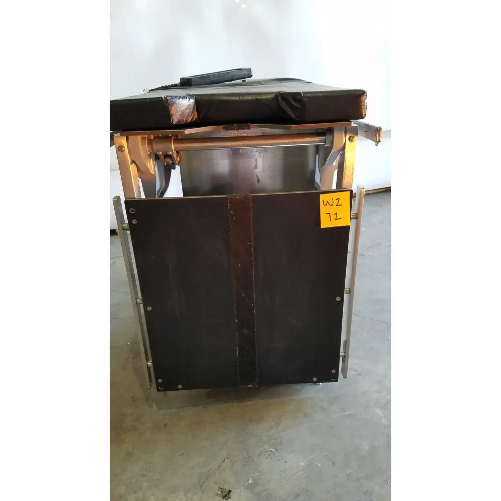 Black padded skytron 1700 surgical table with metal frame and hand control for medical equipment use