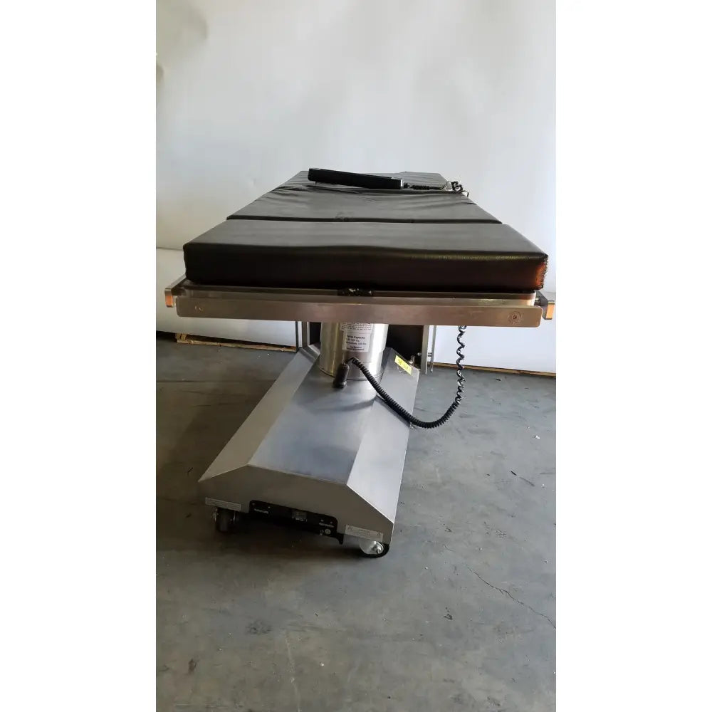 Skytron 1700 surgical table with hand control black padded top stainless steel frame and wheeled base medical equipment