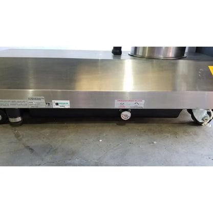 Stainless steel surgical table with polished countertop and black undercarriage featuring hand control for reuse medical use