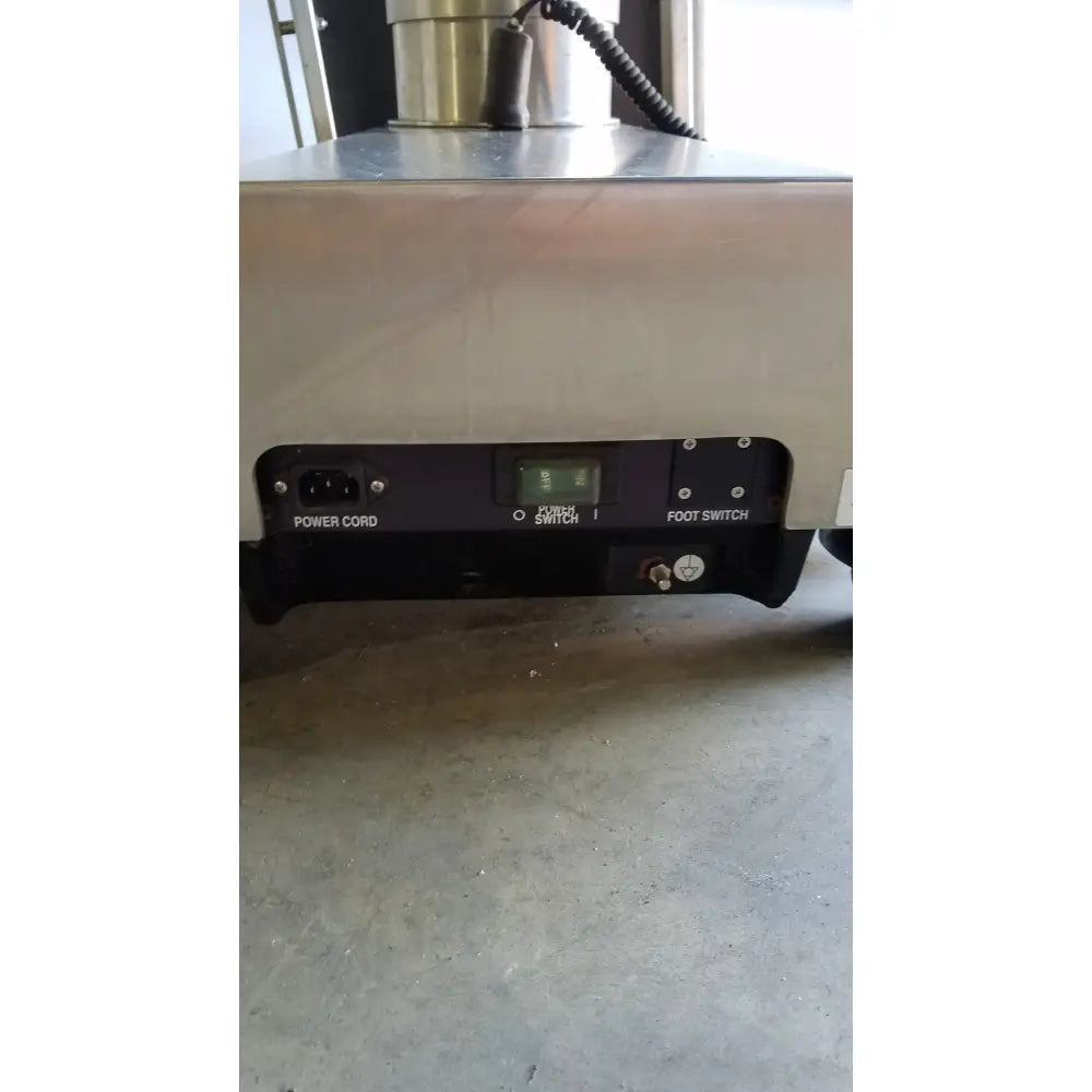Industrial stainless steel Skytron 1700 surgical table with black hand control panel and labeled power and foot switches