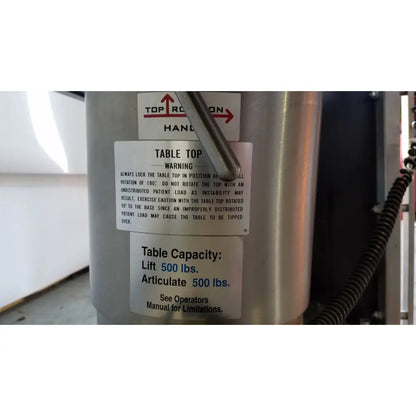 Silver metallic cylindrical table base with warning label and capacity specs for skytron 1700 surgical table with hand control medical equipment