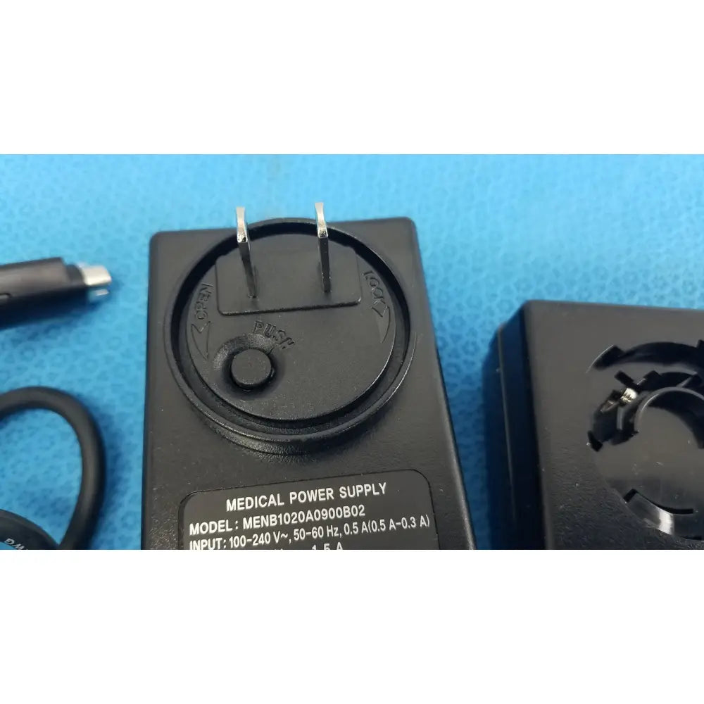Black plastic medical power supply menb1020a0900b02 with two prongs and circular dial for medical equipment use