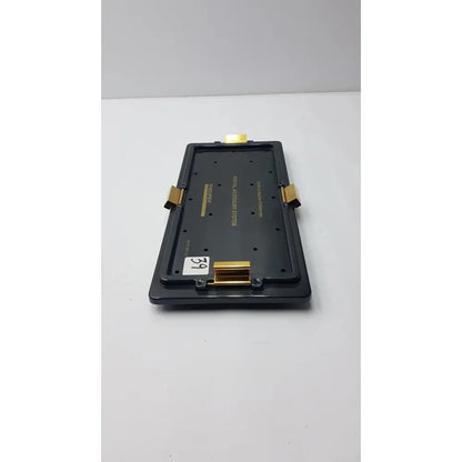 Black plastic smith & nephew endoscopy portal accessory tray with gold metal clips and white price tag