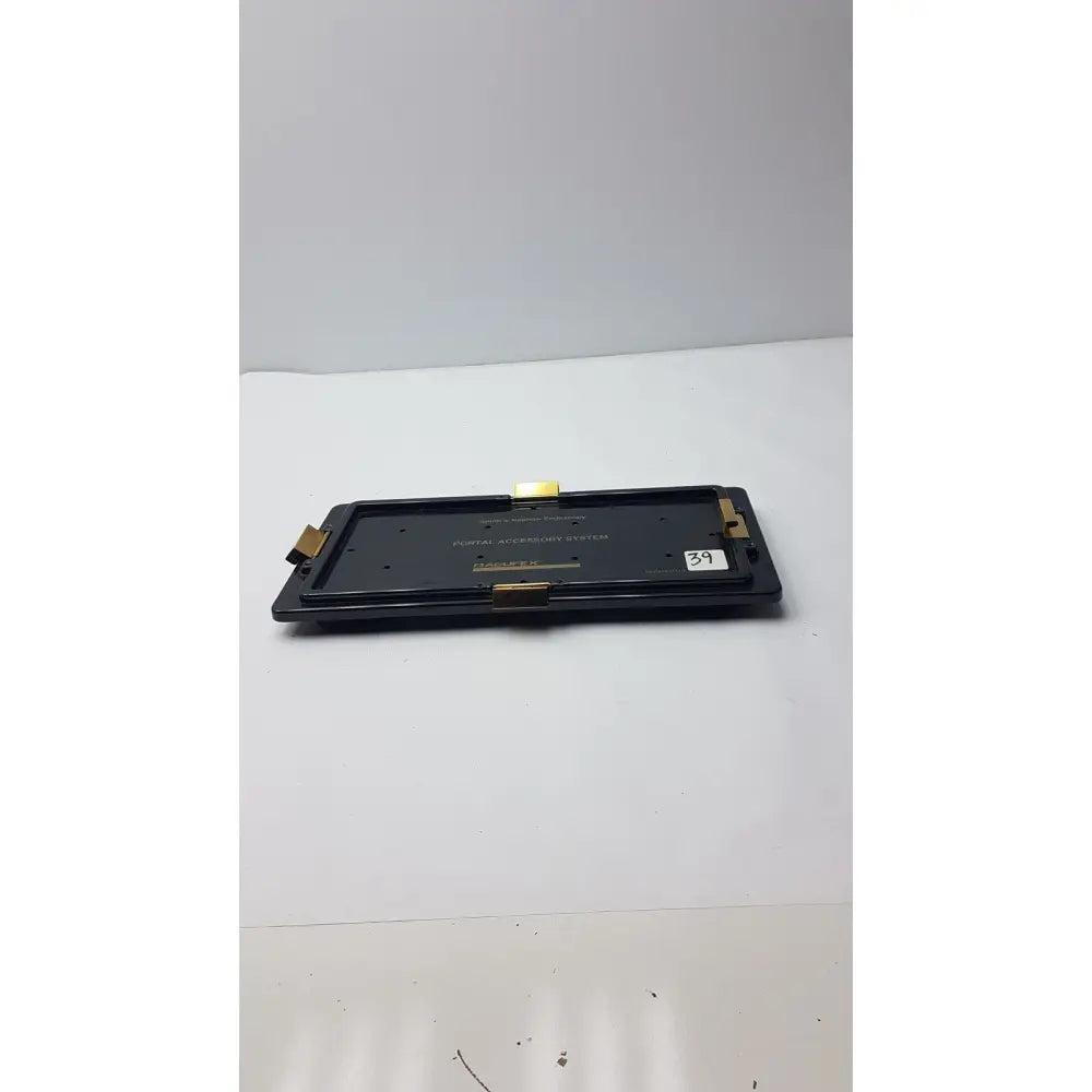 Black rectangular digital audio player with gold metallic accents and white 39 sticker for nephew endoscopy portal accessory system