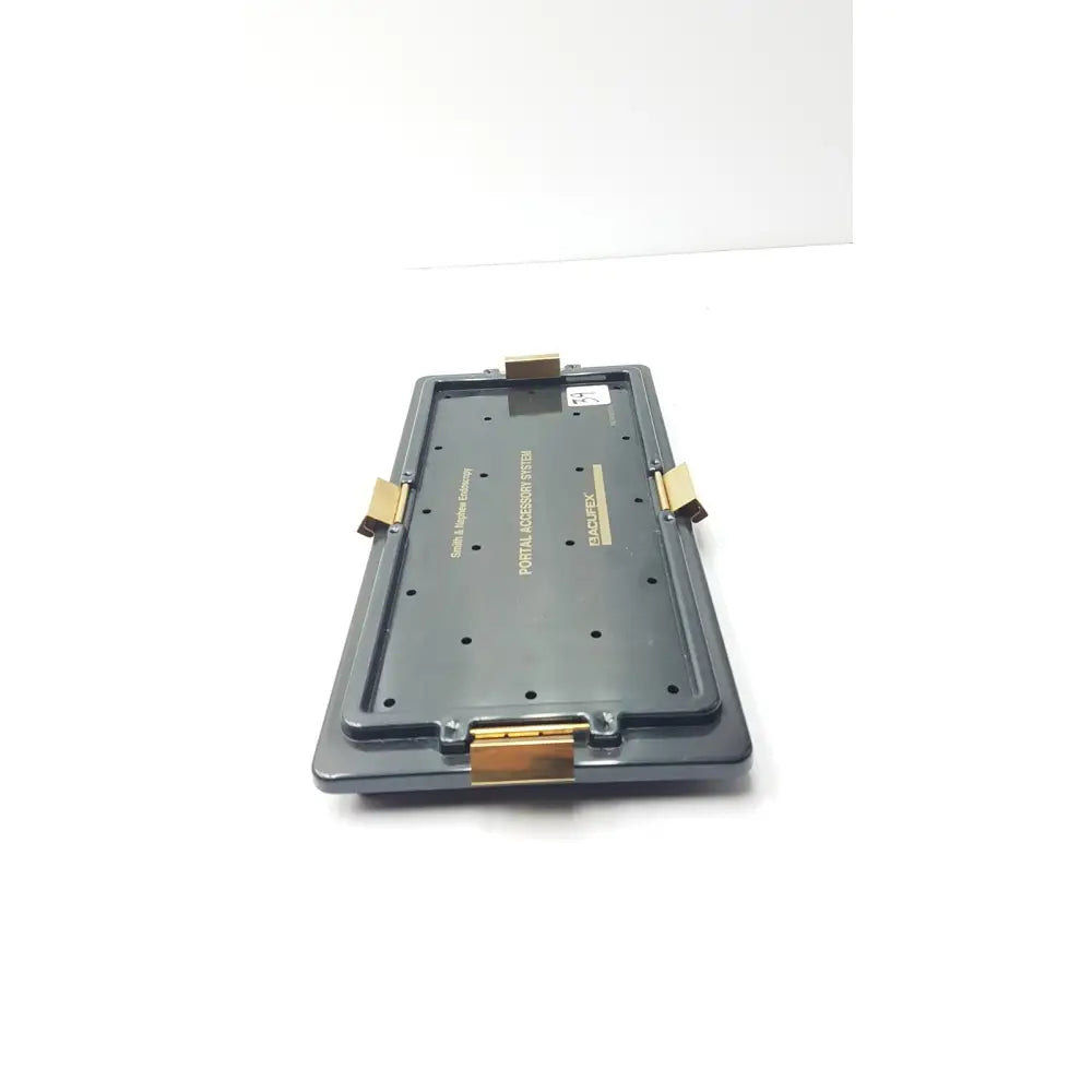 Black plastic smith & nephew endoscopy portal accessory stash with gold-tone metal clasps and hinges