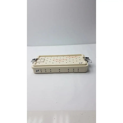 Cream-colored plastic smith & nephew ref 7207934 hip arthroscopy empty tray with metal clamps and grid holes