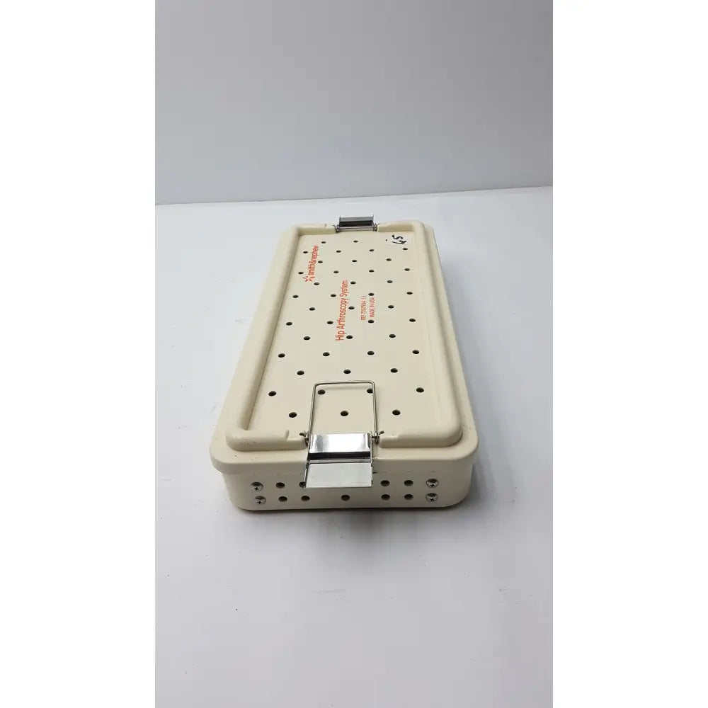 Beige plastic hip arthroscopy empty tray with metal clasp and perforated lid smith & nephew ref 7207934