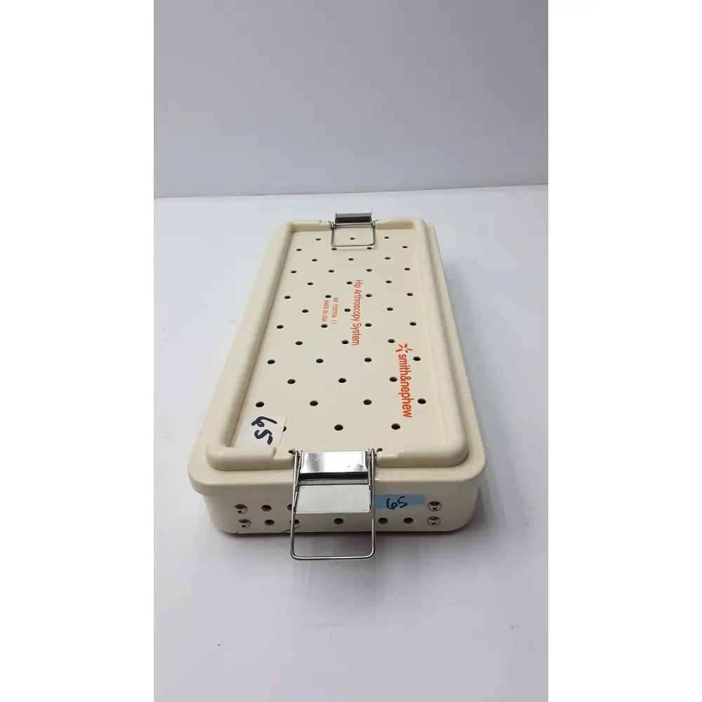 Cream-colored Smith & Nephew ref 7207934 hip arthroscopy empty tray with perforated surface and metallic clasp