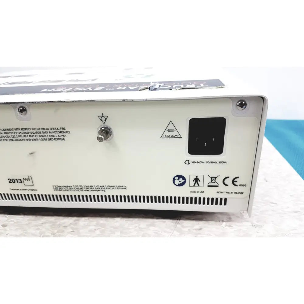 White rectangular nephew truclear hysteroscopic morcellator console back with black power input port and safety labels