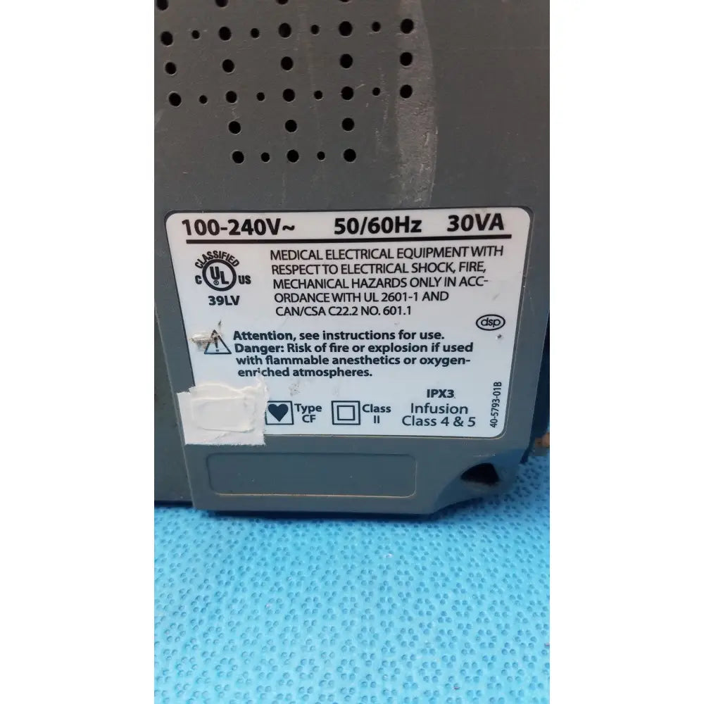 Gray medical electrical equipment with perforated casing and white label showing specifications of smiths medfusion 3500 with rotating pole clamp