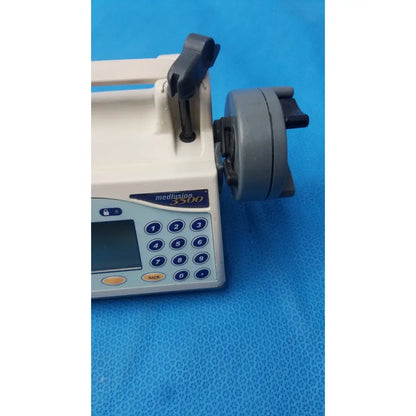 Beige and gray smiths medfusion 3500 infusion pump with digital keypad blue buttons and rotating pole clamp mechanism
