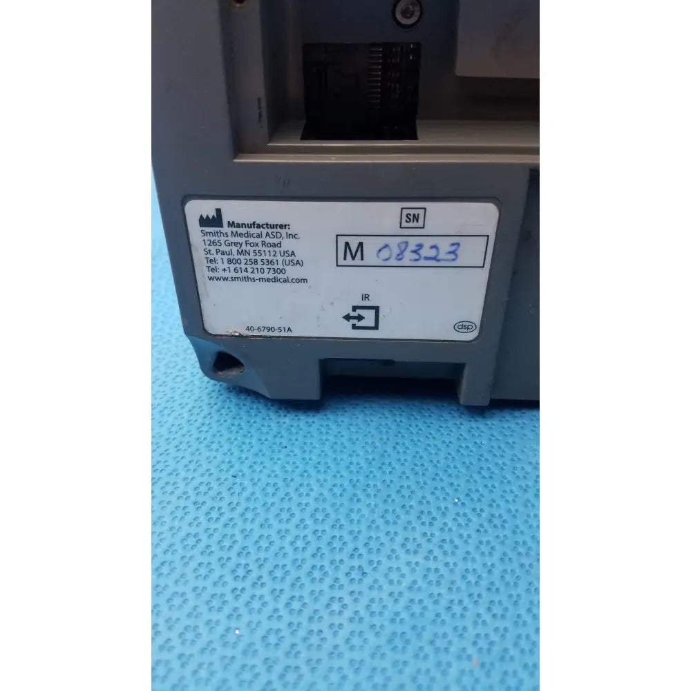 Gray plastic smiths medfusion 3500 medical device with rotating pole clamp and visible manufacturer label and serial number