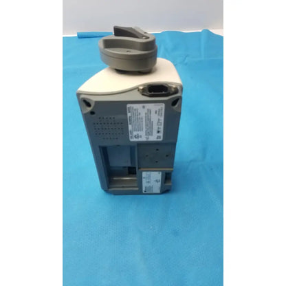 Gray and beige smiths medfusion 3500 medical device with circular top handle and rotating pole clamp for secure mounting