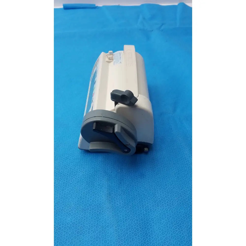 Beige and gray smiths medfusion 3500 medical device with black plastic handle and rotating pole clamp for secure mounting