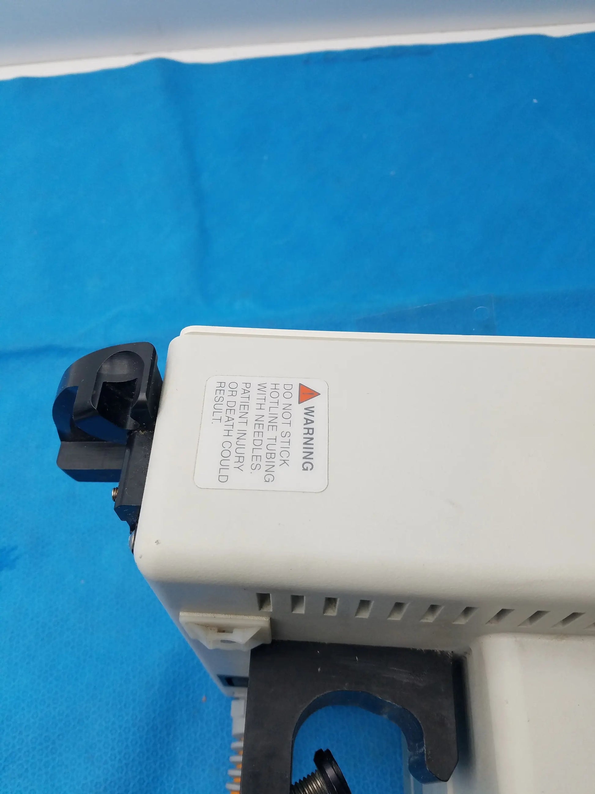 White plastic smiths medical fluid warmer control box unit with black components and a warning label for medical equipment