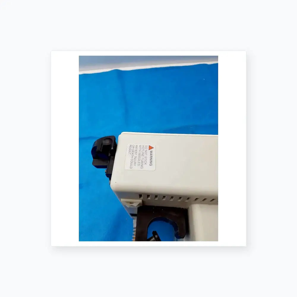 White plastic smiths medical fluid warmer control box unit with black components and a warning label for medical equipment
