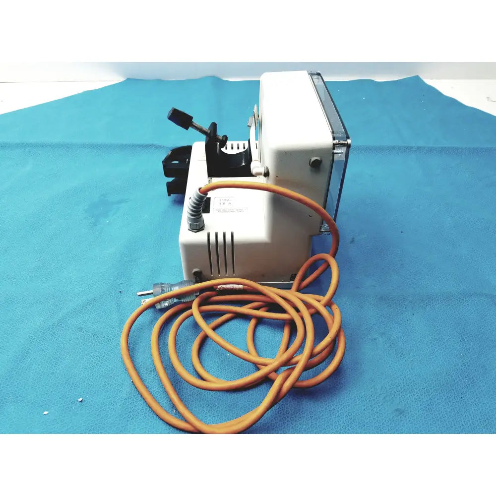 White industrial-grade vacuum pump with coiled orange cord and black components for smiths medical fluid warmer medical equipment