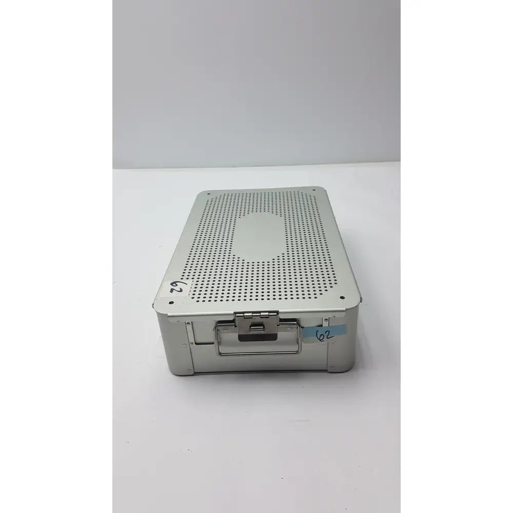 Solid brass sterilization storage container with silver metallic perforated lid and numbered label for sterilization use