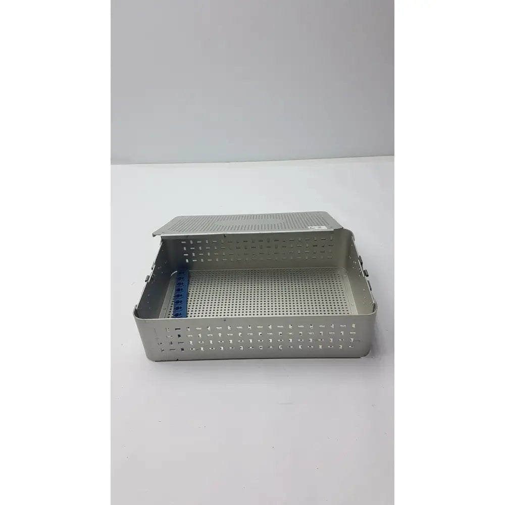 Solid brass sterilization storage container with silver perforated metal tray hinged lid and blue plastic divider