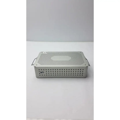 Solid brass sterilization storage container with lid and perforated silver metallic surgical instrument tray with side handles