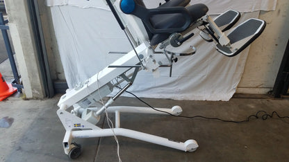 White adjustable Sonesta S3 ultimate patient positioning procedure chair with black padded seat and blue control knob on armrest