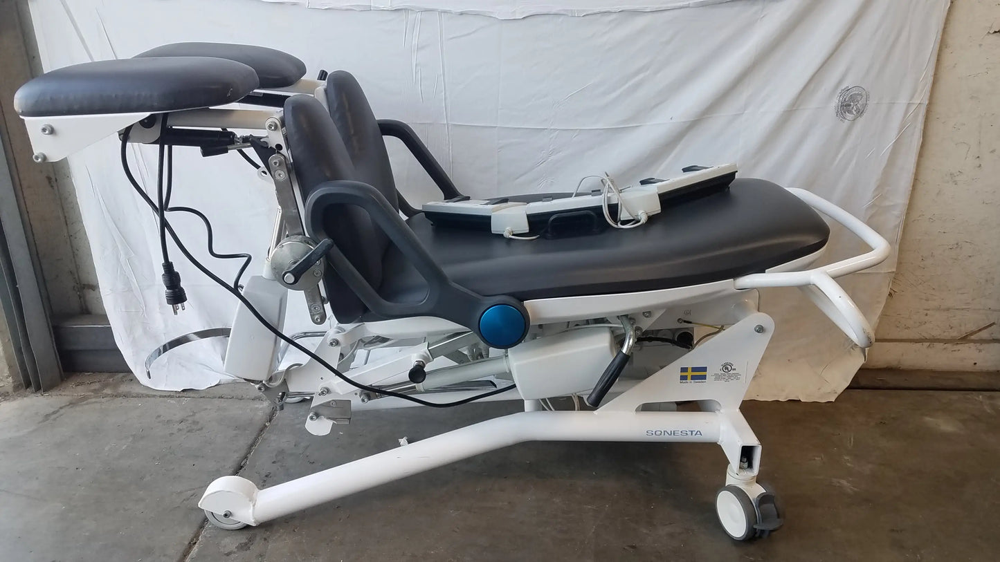 White sonesta s3 ultimate patient positioning procedure chair with black padded surfaces and adjustable components