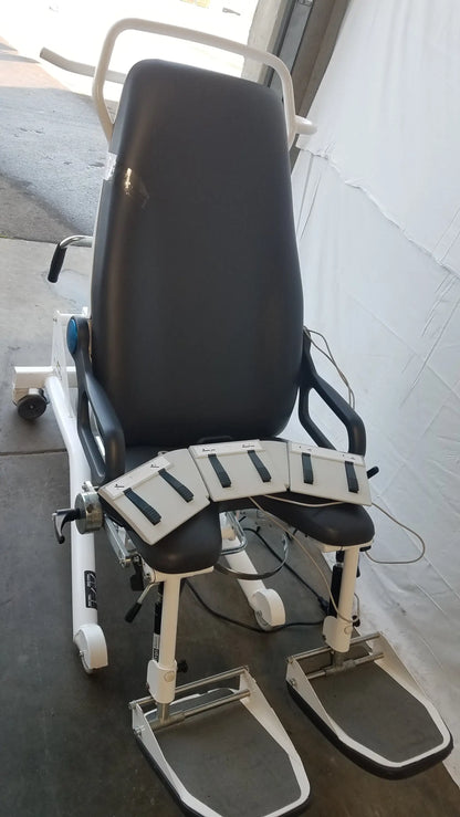 White and black Sonesta S3 ultimate patient positioning procedure chair with padded seating and adjustable footrests