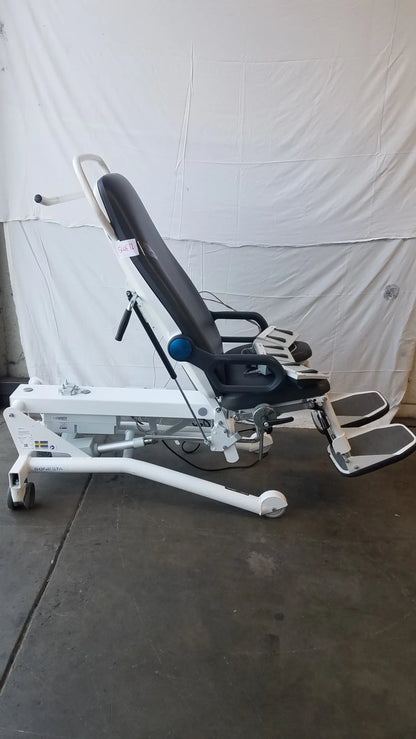 White and black adjustable Sonesta S3 ultimate patient positioning procedure chair with padded seat and control levers