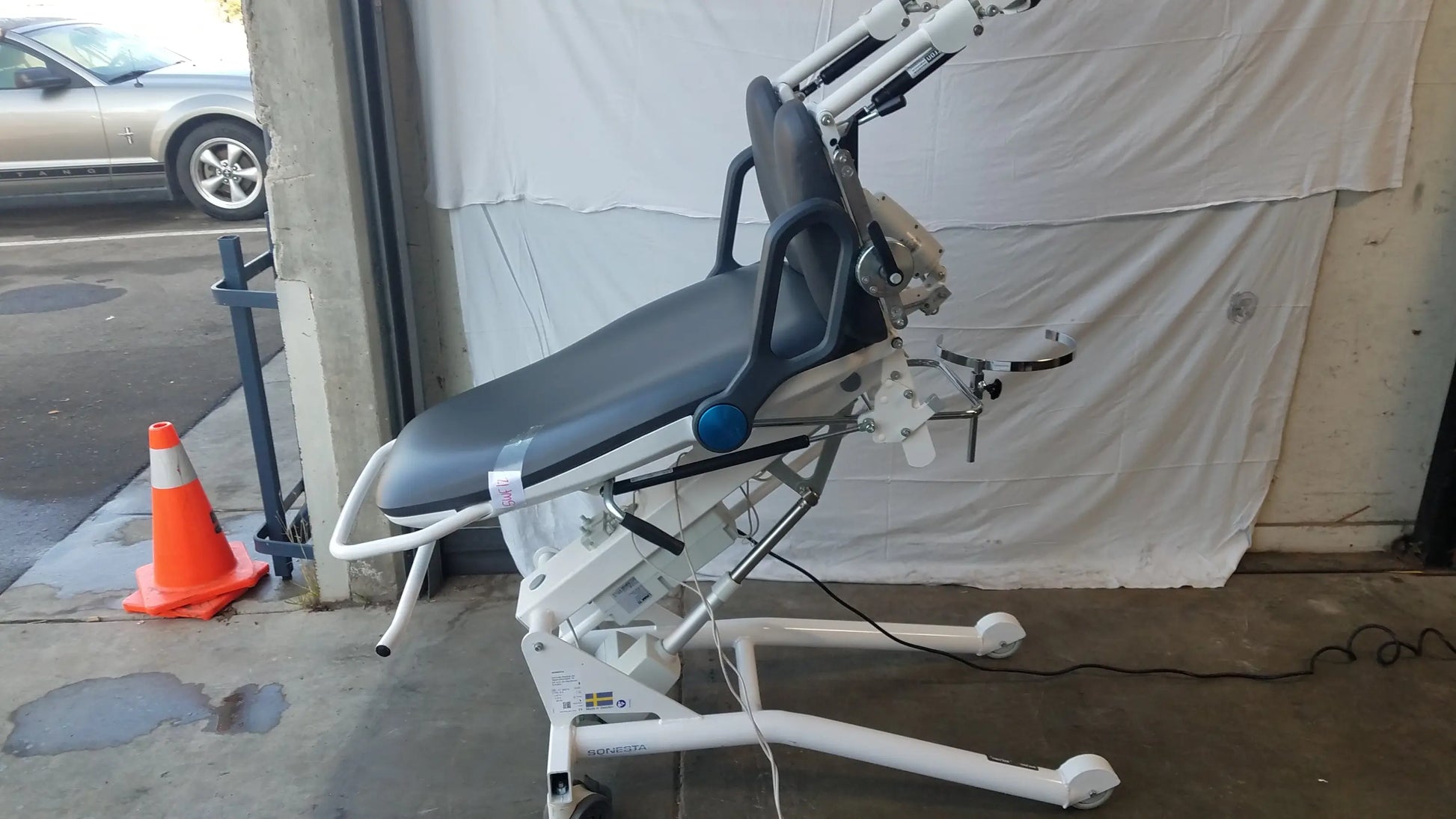 White electric sonesta s3 ultimate patient positioning procedure chair with black padded seat, adjustable armrests, and head support