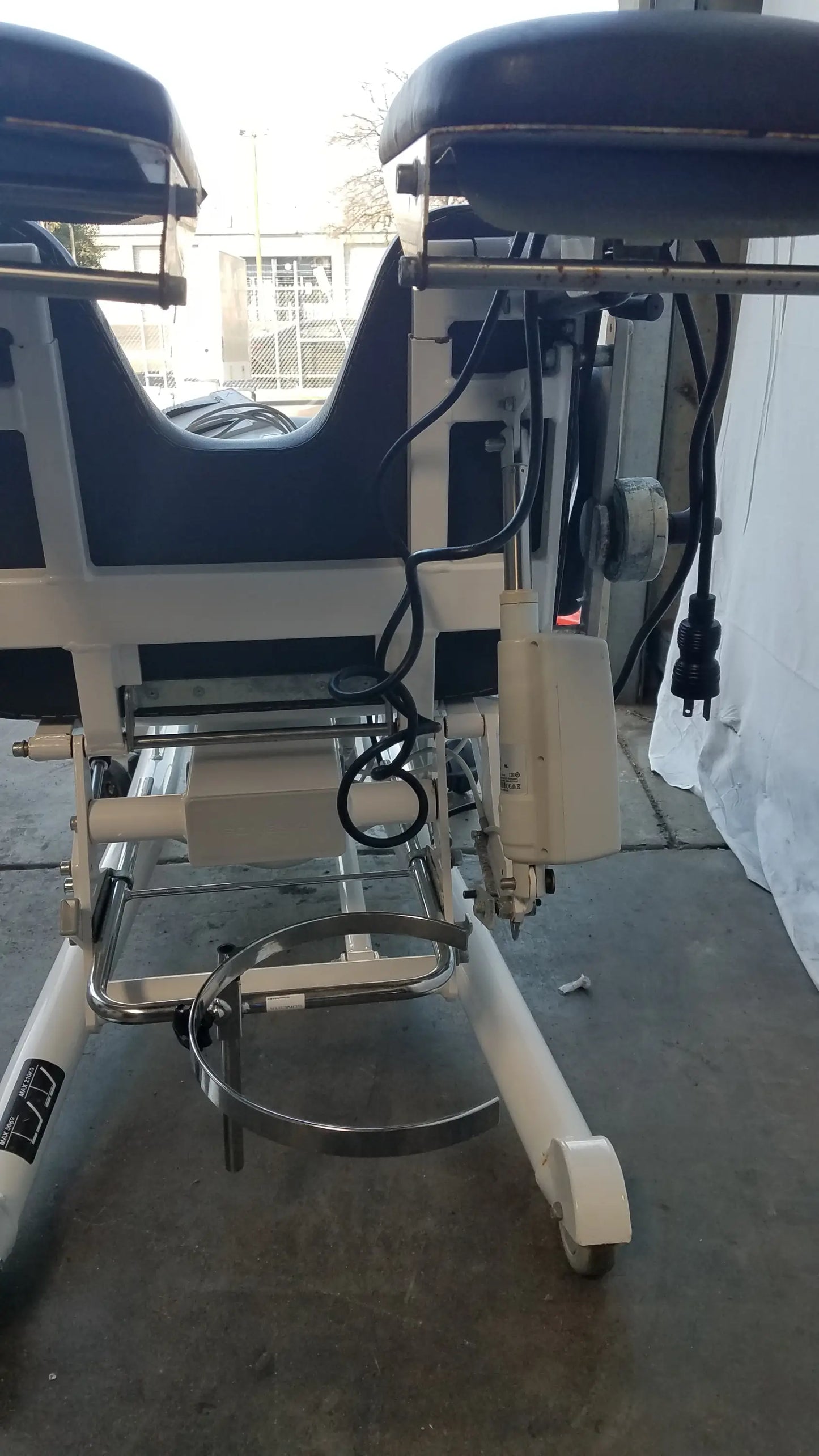 Sonesta s3 ultimate patient positioning procedure chair with dark blue padded surface and white metal frame