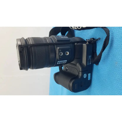 Black nikon dslr camera with mounted lens and strap shown alongside sony cyber-shot dsc-f828 digital still camera with adapter