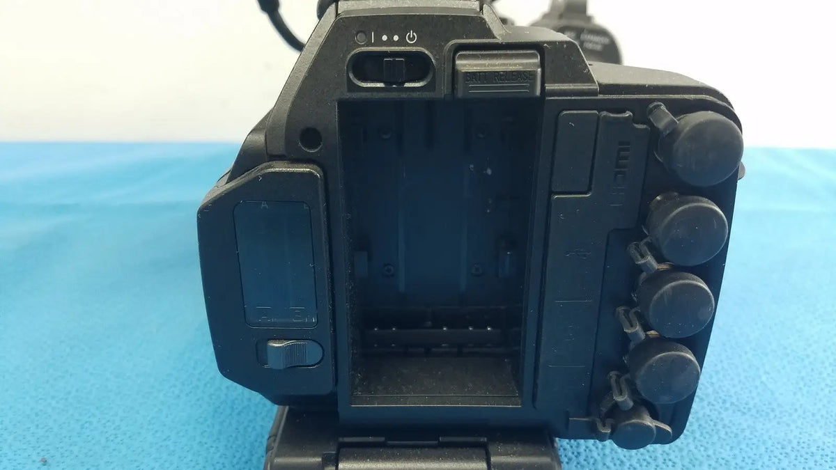 Black plastic sony pmw-300 memory xdcam camcorder body with control dials and battery compartment visible