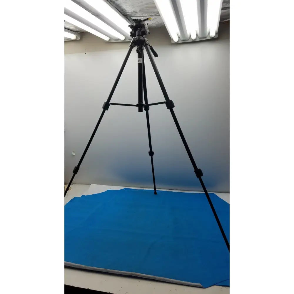 Black lightweight extendable video tripod Sony VCT-R640 with adjustable legs and camera mount on blue backdrop