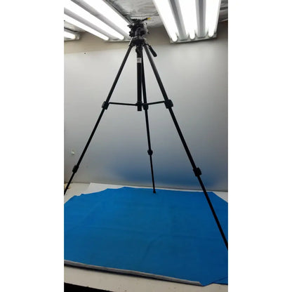 Black lightweight extendable video tripod Sony VCT-R640 with adjustable legs and camera mount on blue backdrop