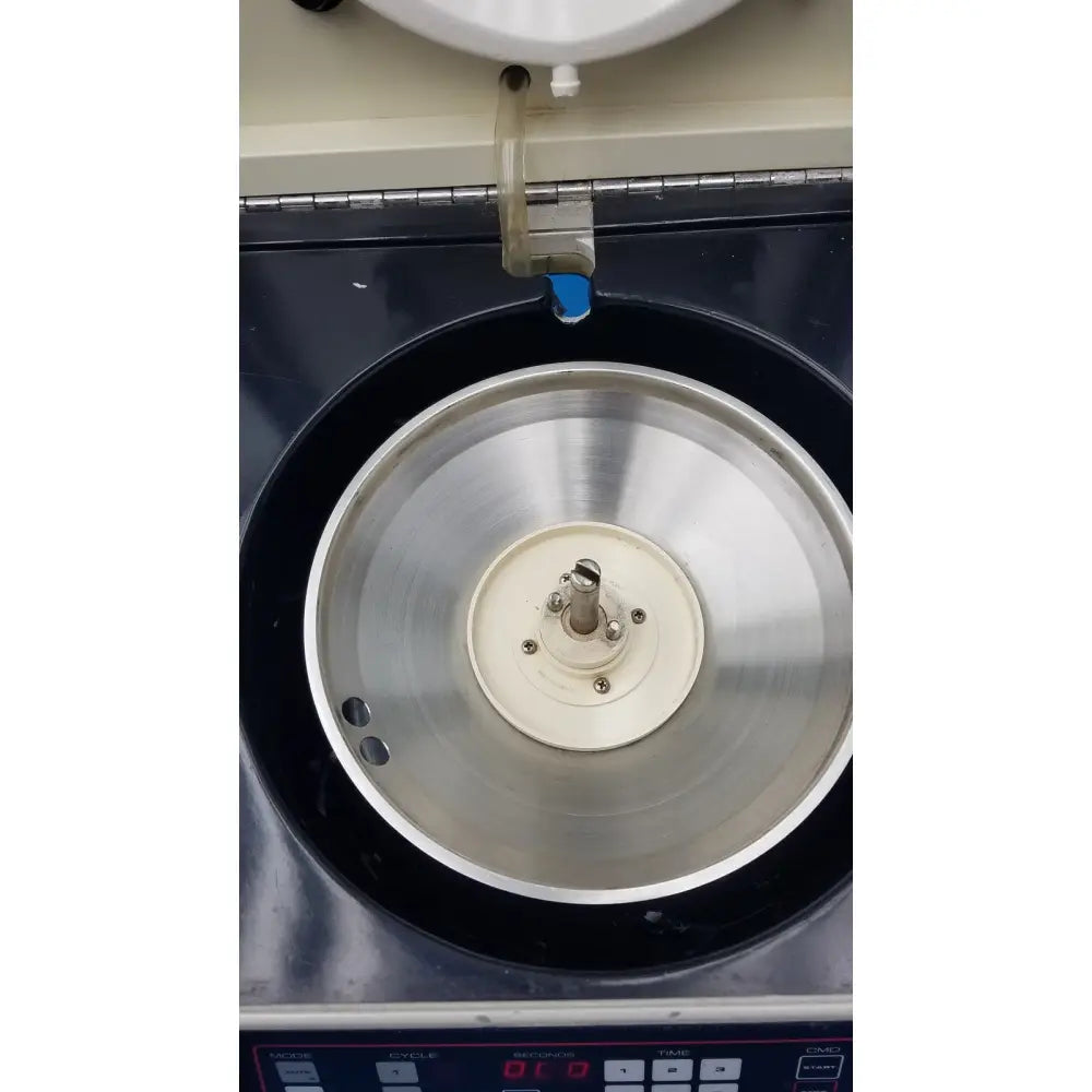 Silver metallic rotor with central white hub and screws inside black chamber of sorvall cell washer centrifuge cell washing system