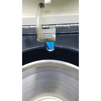 Translucent plastic tube with metallic hinge attached to black appliance side of sorvall cell washer centrifuge cell washing system