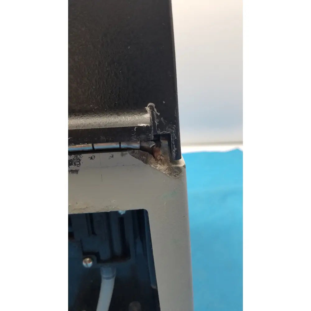 Black plastic corner with rusted metal hinge on the back of sorvall instruments cell washer 2 appliance