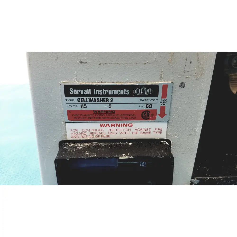 White and black label on a white sorvall instruments cell washer 2 with voltage specifications visible on industrial machine