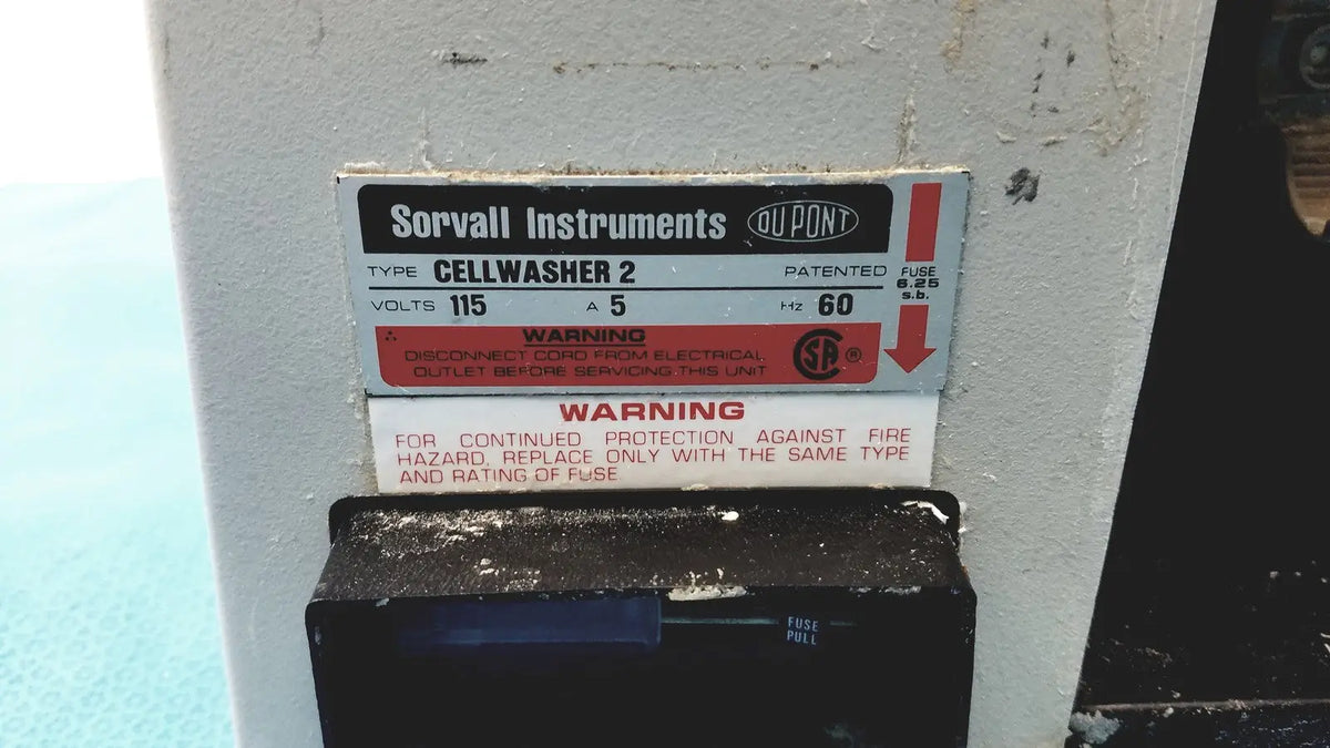 White and black label on a white sorvall instruments cell washer 2 with voltage specifications visible on industrial machine