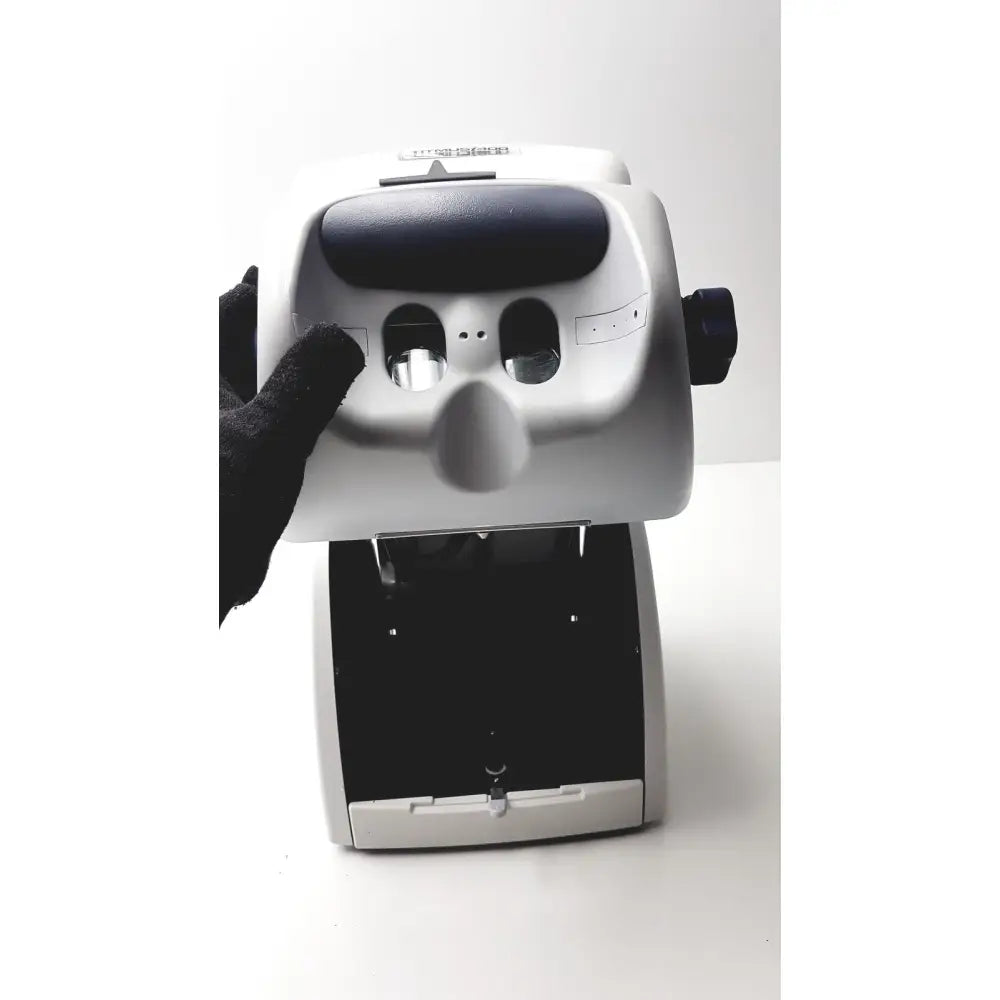 Silver and black matte sperian titmus i300 vision screening instrument with two circular openings on front panel