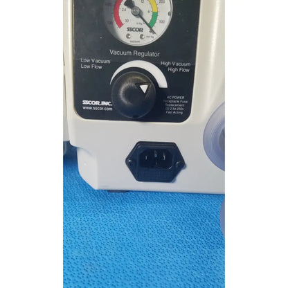 White plastic vacuum regulator with black control dial and power port on sscor duet suction unit model 2314b back side