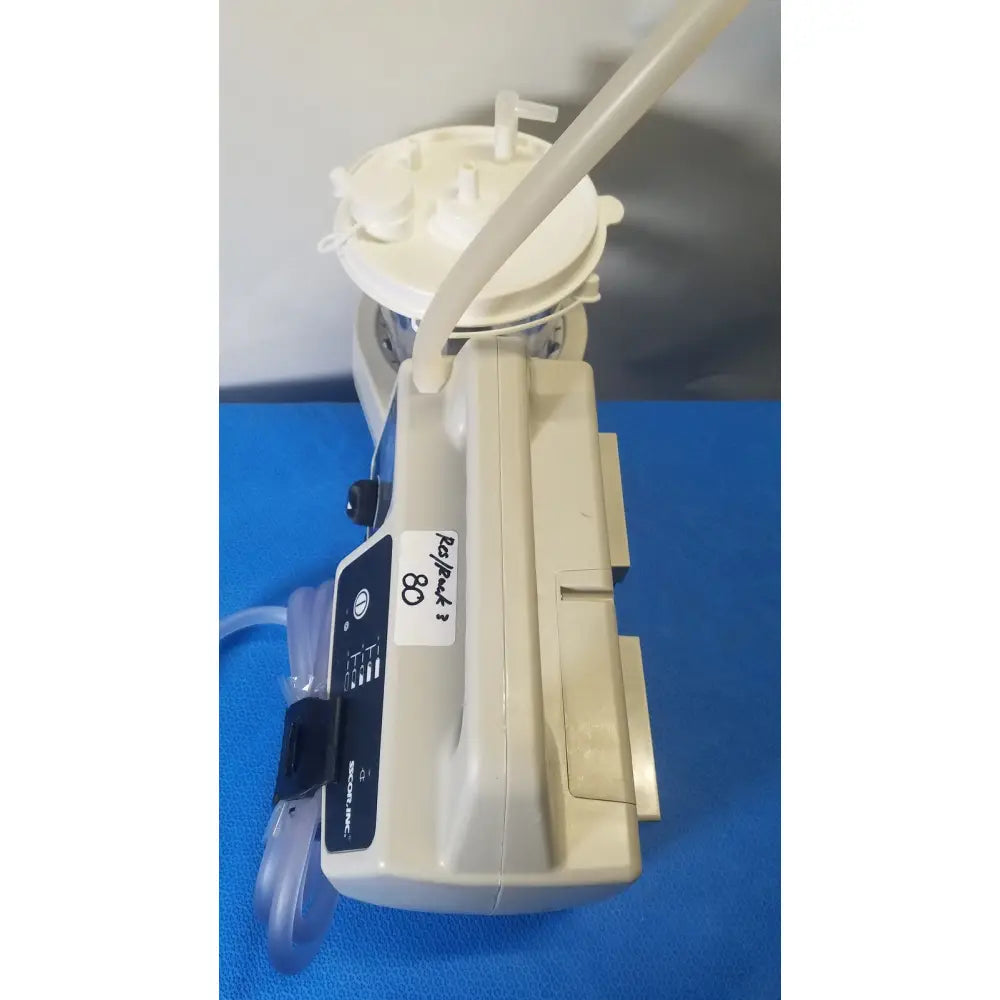 Beige plastic sscor duet suction unit model 2314b with white circular top and attached tubing for surgical use