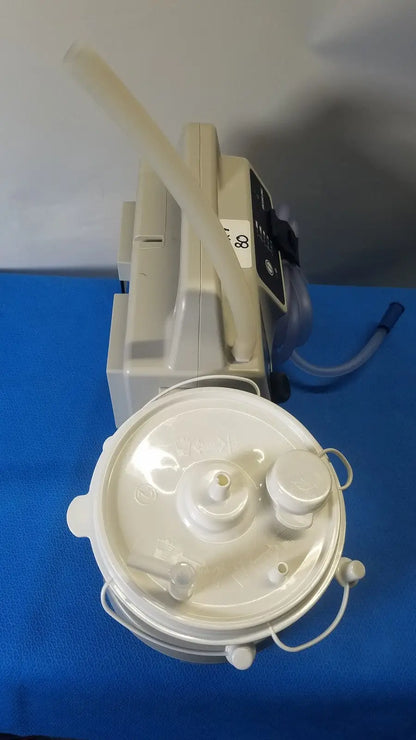 White plastic sscor duet suction unit with circular base and attached tubing model 2314b for medical use