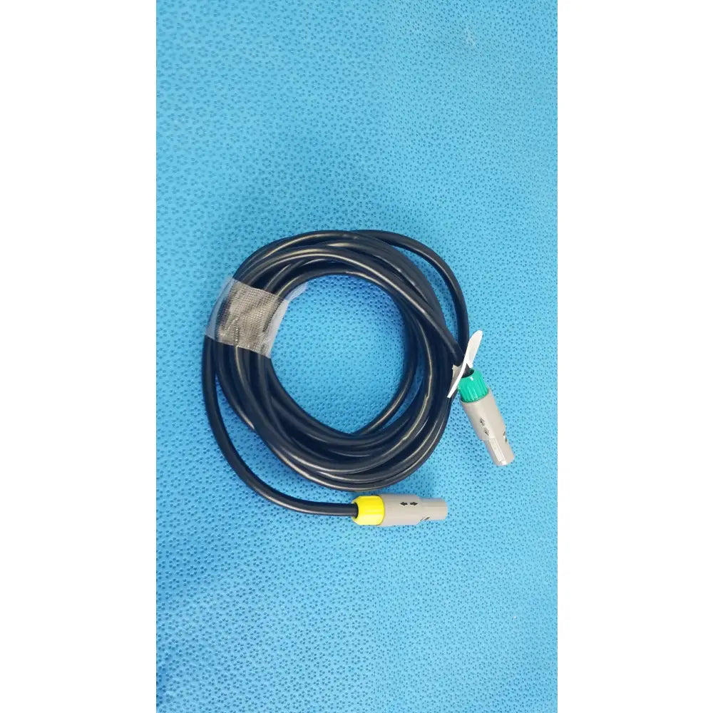Black coiled catheter connection cable with gray connectors and green and yellow accents for reuse medical equipment